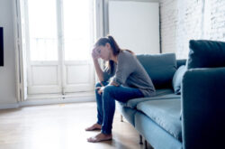 Young attractive latin woman lying at home living room couch feeling sad tired and worried suffering depression in mental health, problems and broken heart concept.