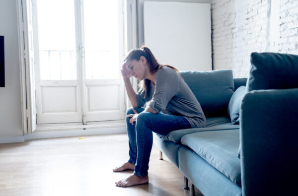 Young attractive latin woman lying at home living room couch feeling sad tired and worried suffering depression in mental health, problems and broken heart concept.