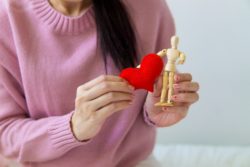 Woman holding a wooden figure and velt heart