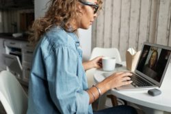 Middle aged woman sitting in front of her computer on a video call