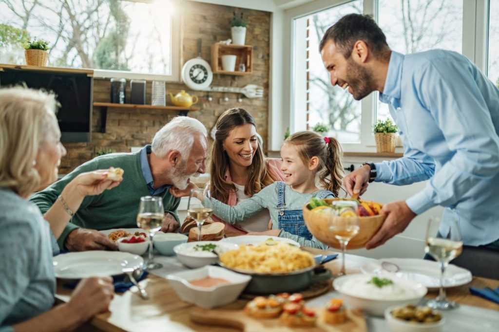 Generations of a family sitting around the dinner table enjoying each others company