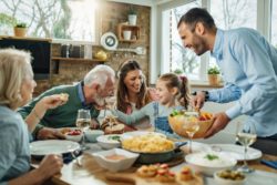 iStock-1215369487 Generations of a family sitting around the dinner table enjoying each others company