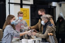 iStock-1283368382 Elderly woman receiving food from a soup kitchen during the pandemic