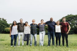 Happy diverse people hugging each other in the park