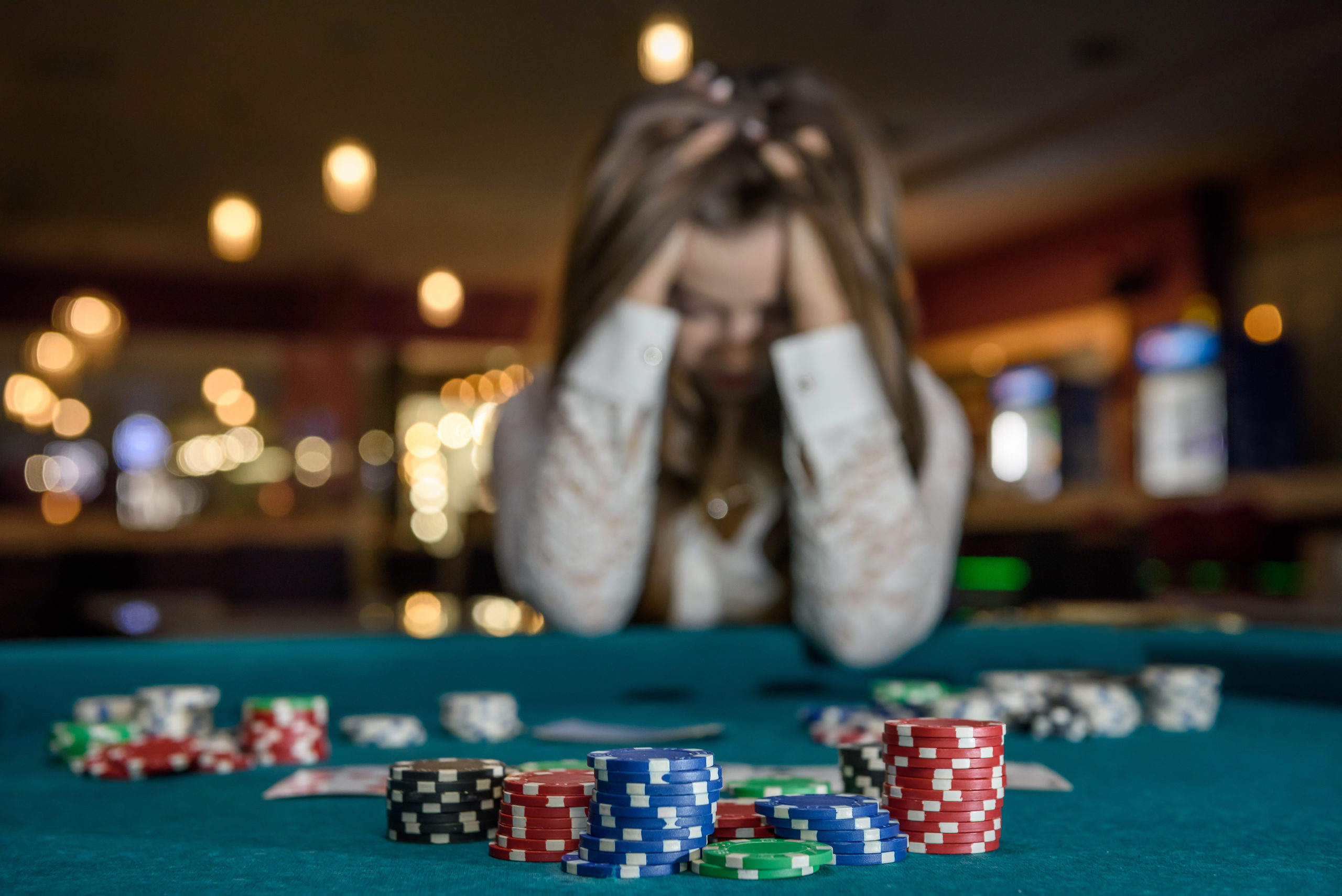 Upset woman in casino sitting behind poker table