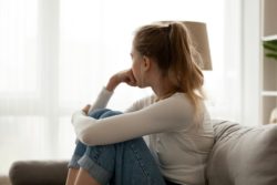 Woman Sitting Alone on Couch Thinking Woman Sitting Alone on Couch Thinking