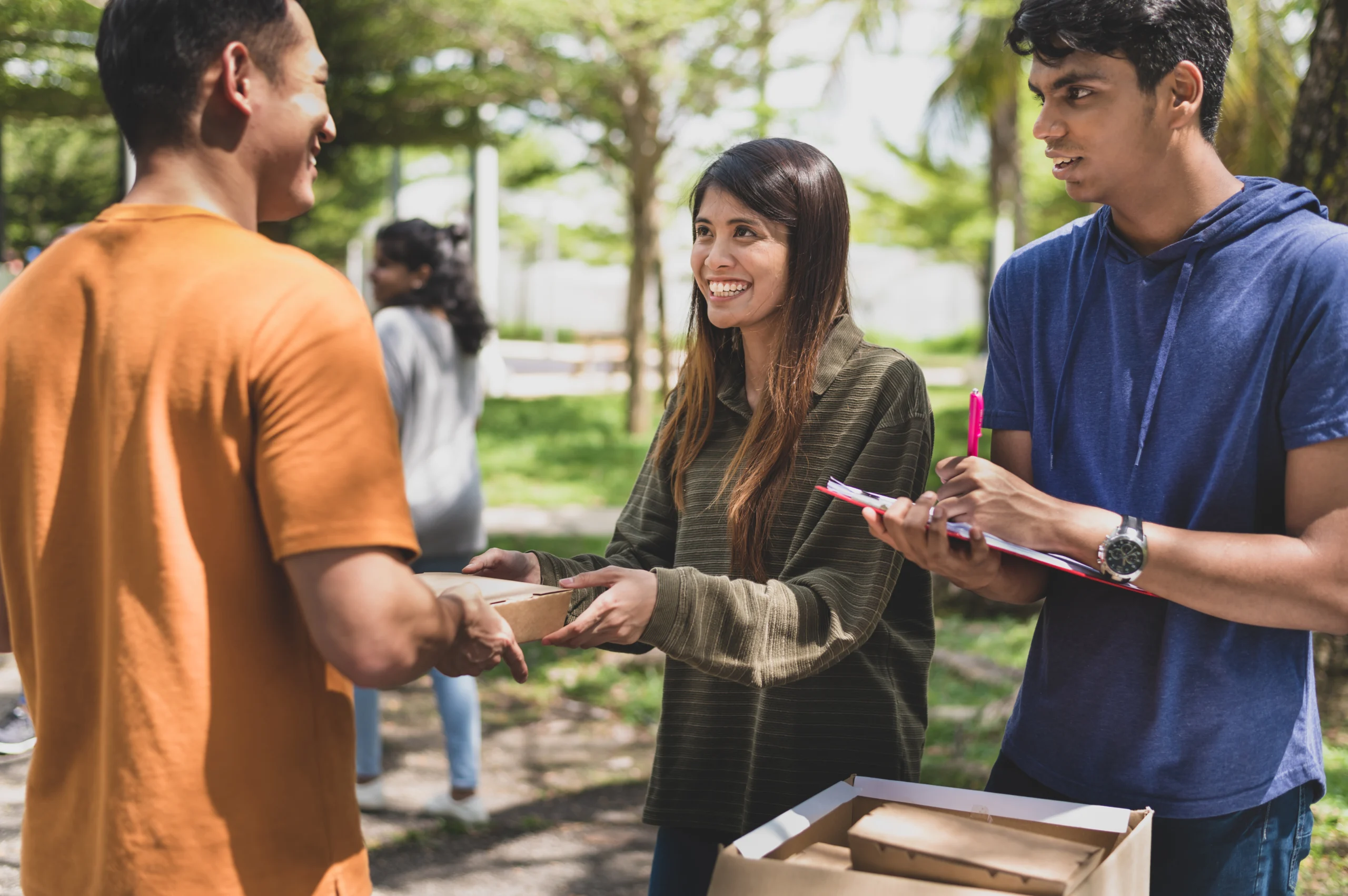a-group-of-helpful-volunteers-arranging-and-packing-cardboard-boxes-with-free-meals-and-give-away-to-any-needy-families-and-local-community-facing-financial-difficulty-during-an-outdoor-charity-food-d-stockpack-gettyimages