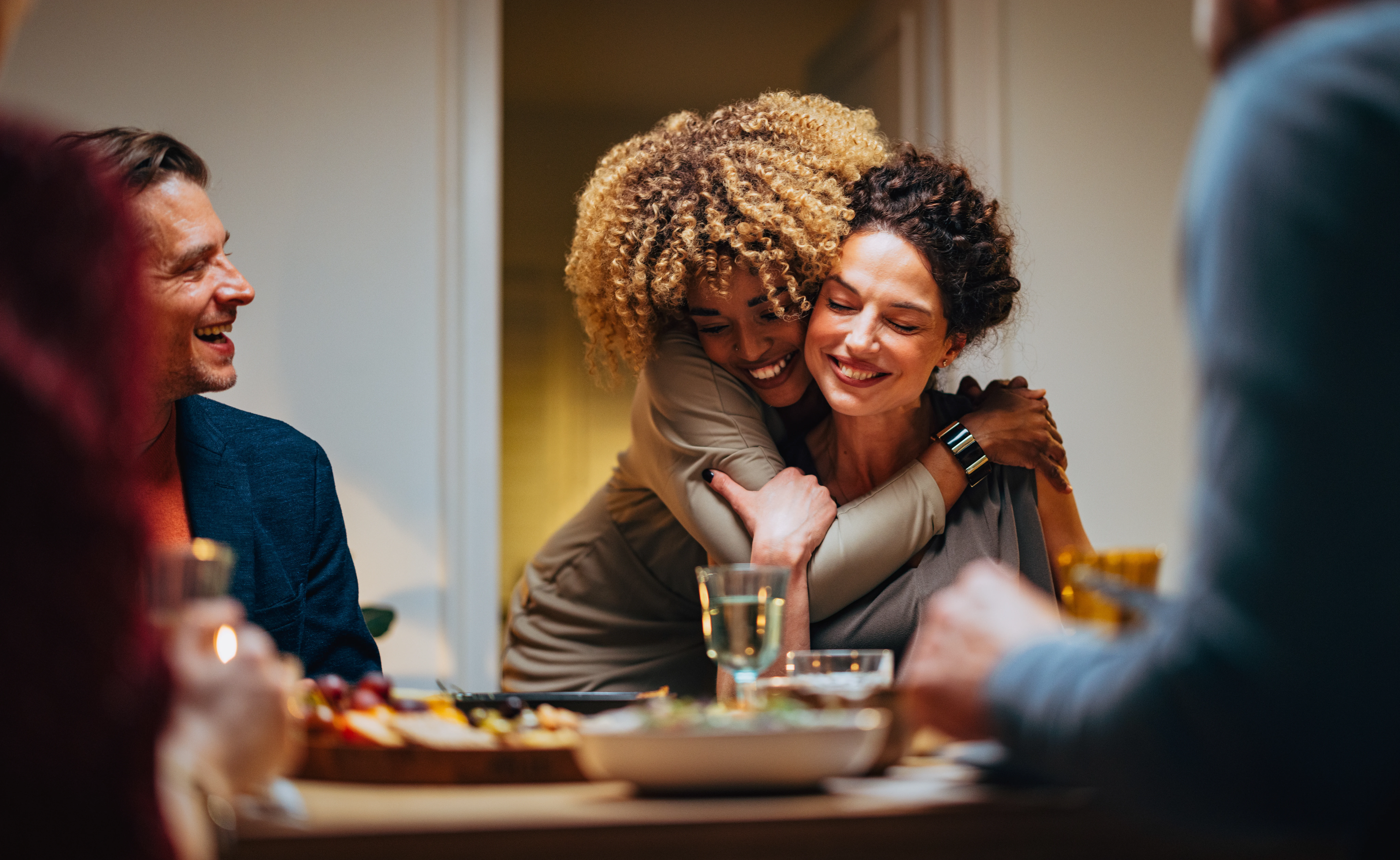 cheerful-smiling-african-american-woman-embracing-her-female-friend-during-a-dinner-with-family-and-friends-stockpack-gettyimages Cheerful smiling African-American woman embracing her female friend during a dinner with family and friends.