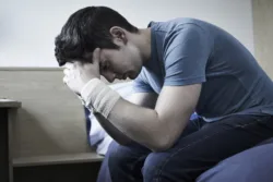 Depressed Young Man With Bandaged Wrists After Suicide Attempt