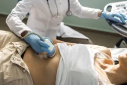 Doctor examining mature woman with ultrasound doing Advanced Liver Disease Monitoring