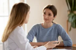 I trust my GP. Millennial female or teenage girl student patient visitor of clinic discussing problem diagnosis with trusted physician, listening to explanations and advices of good capable specialist