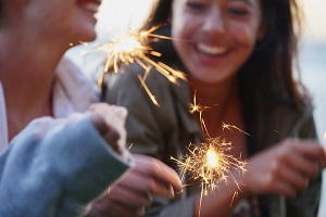 Teenage girls celebrating and laughing with bright sparklers