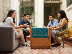 mexican-mother-and-father-sitting-with-their-teenage-children-and-listening-to-their-daughter-stockpack-gettyimages