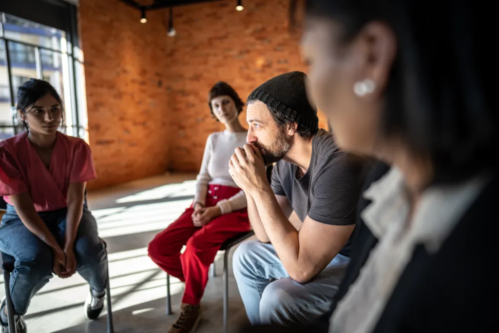 Mid adult man talking during a group therapy