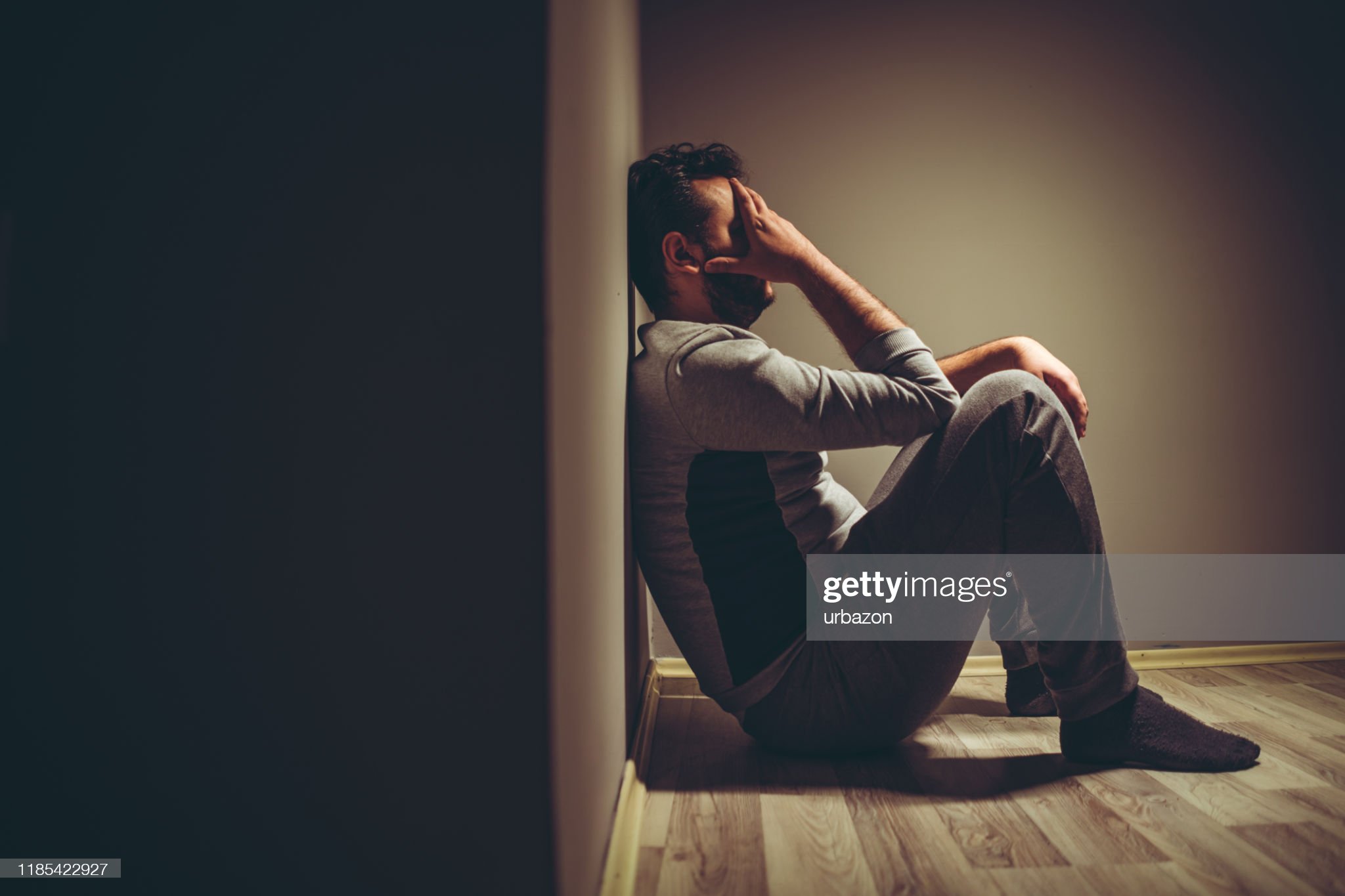 Young depressed man sitting on floor.