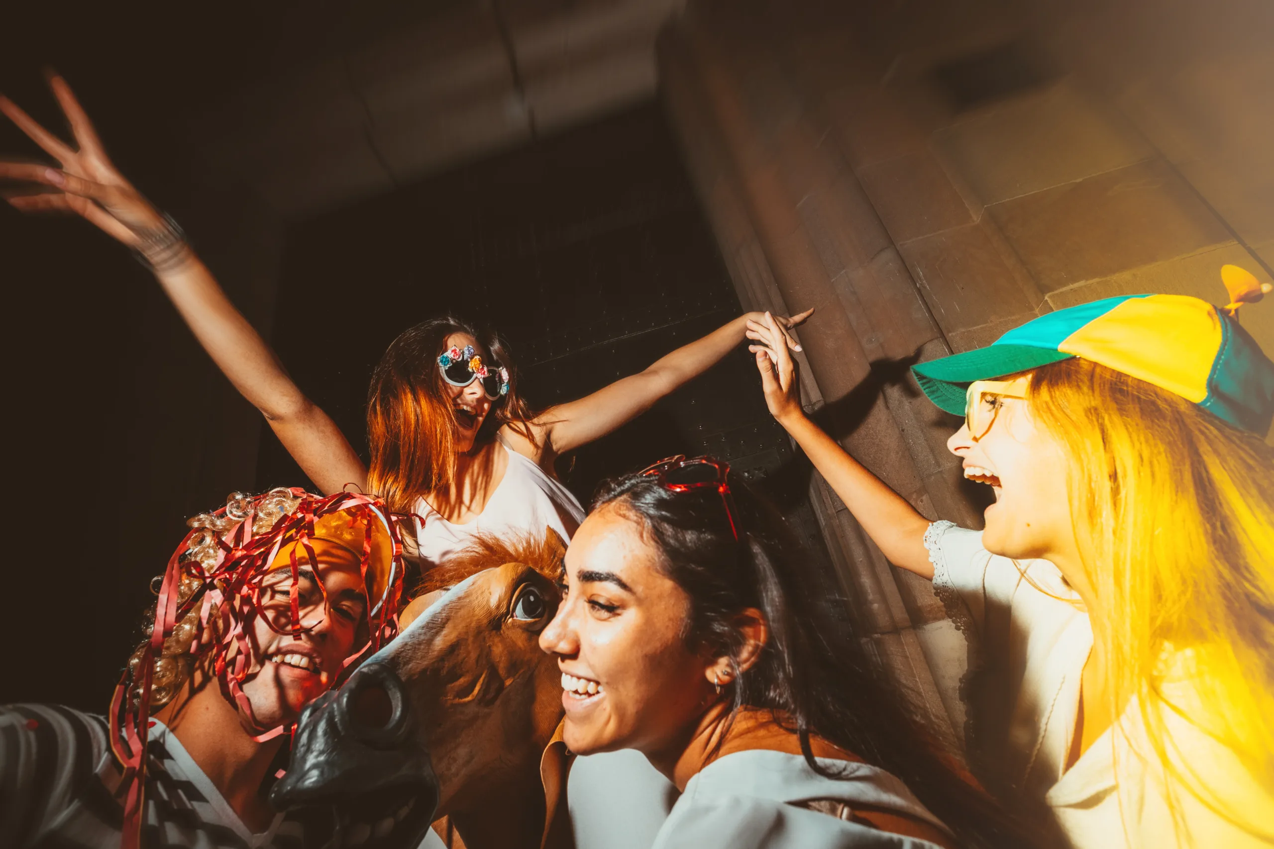 Group of young people enjoying nightlife celebration with sparklers, masks, and playful costumes. Youth culture, festive atmosphere, and vibrant energy captured during an outdoor night party.